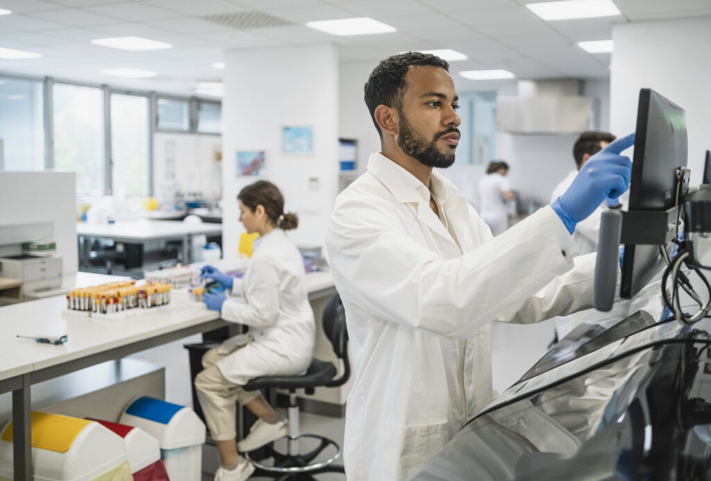 A pharmacists at a standing computer